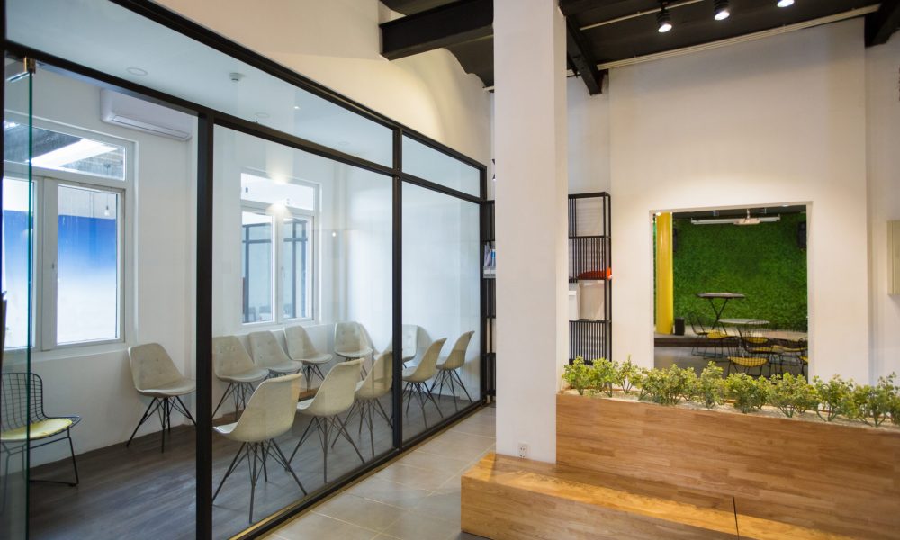Nobody in office lobby with wooden bench Nobody in office lobby with wooden bench. White wall with column and shelves. Green plants as part of interior. Many chairs behind glassy wall. Business center concept